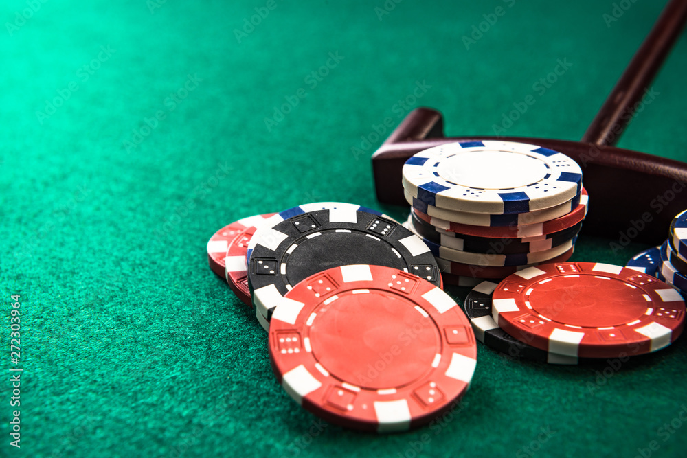 Six tall poker chip stacks in casino colours arranged across a green felt poker table edge