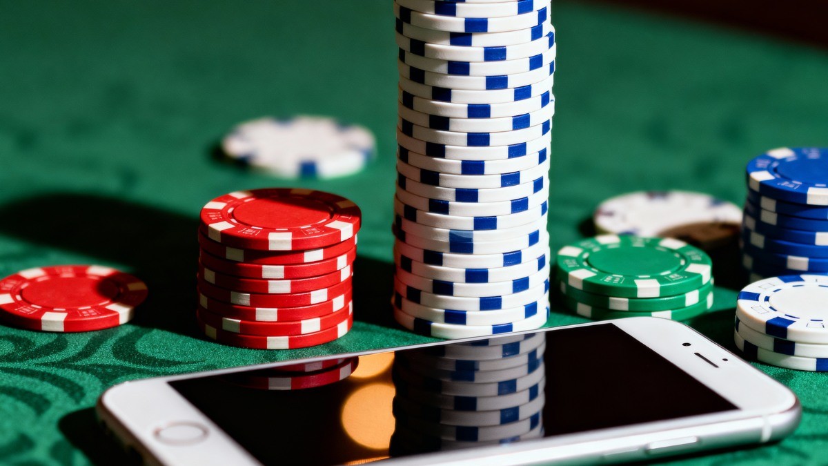 Two king playing cards held above casino chips at a Tab66Plus online casino alternative table